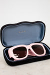 Pink sunglasses in a Gucci case on a light background