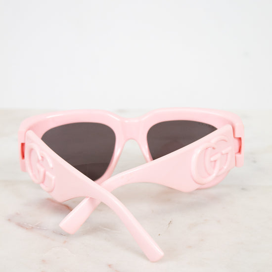 Light pink sunglasses with "GG" logo and dark lenses 