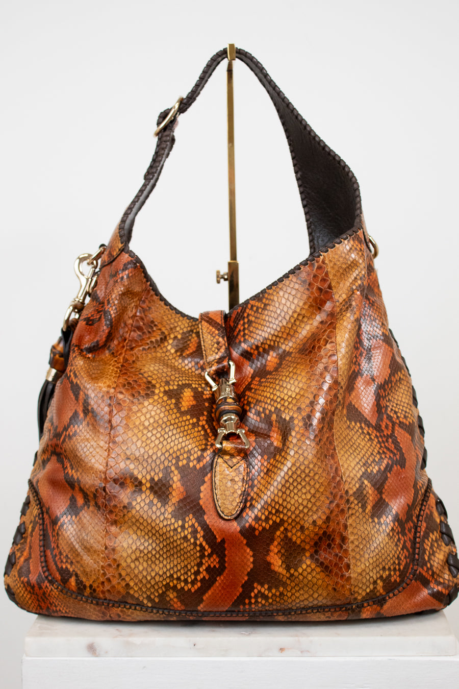 Brown snake skin patterned handbag on a white background