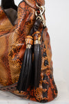 Brown textured handbag with black tassel on a white background