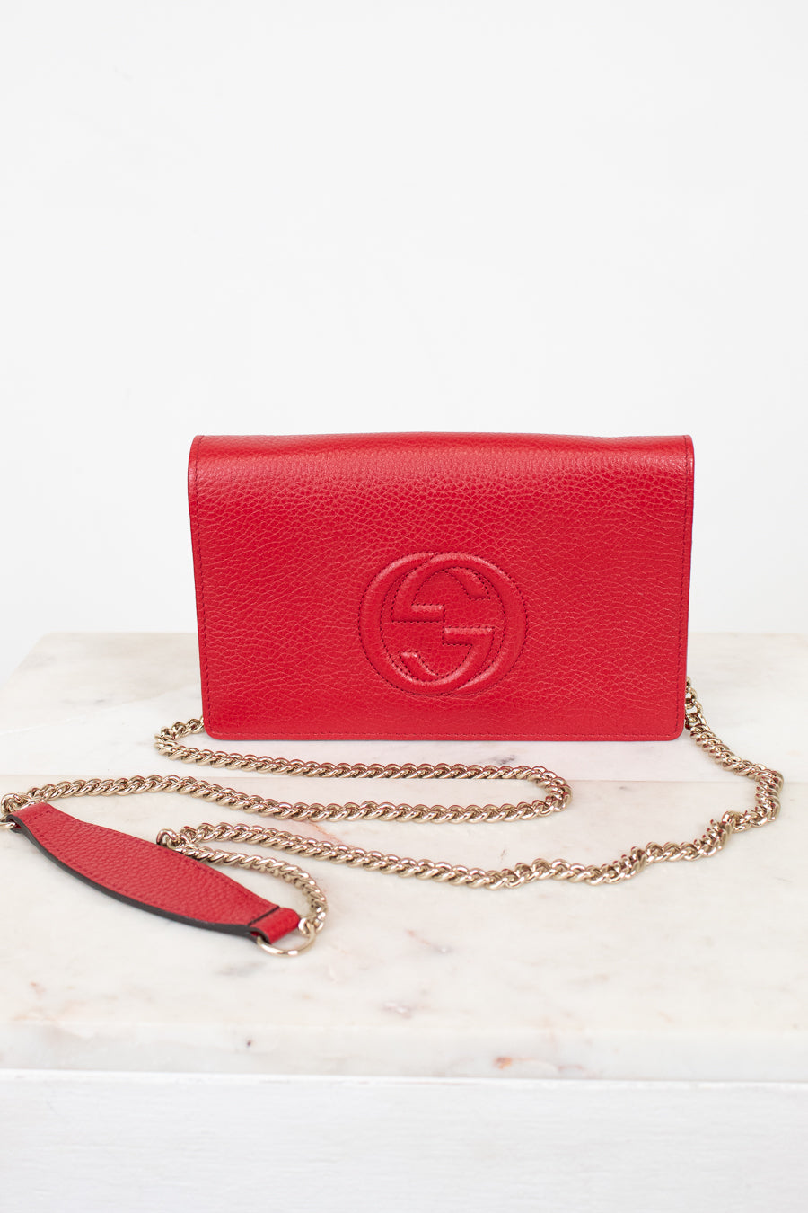 Red handbag with gold chain on a white background