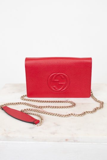 Red handbag with gold chain on a white background