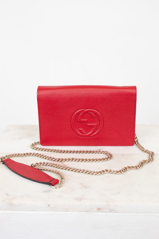 Red handbag with gold chain on a white background