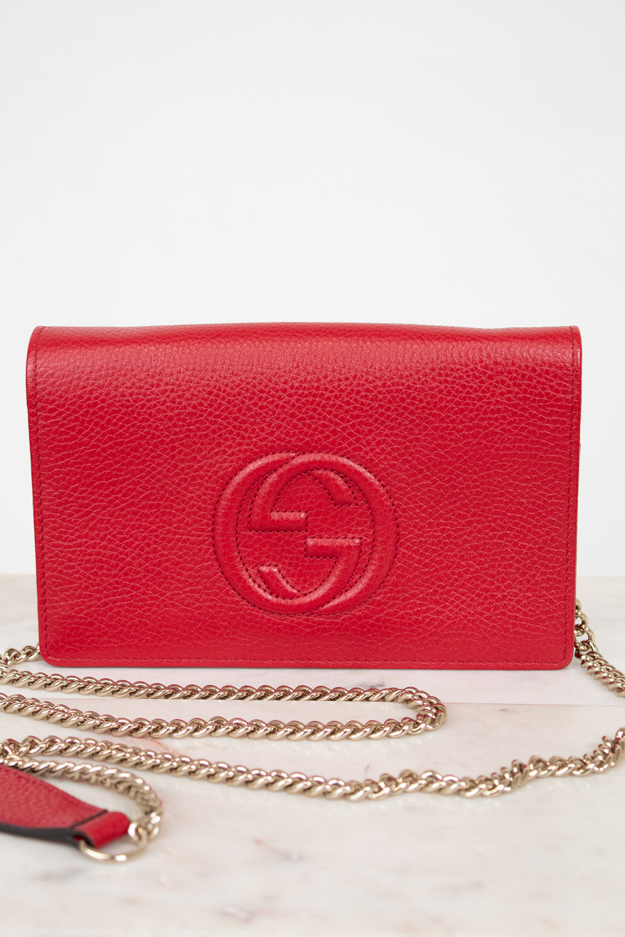 Red handbag with gold chain on a white background