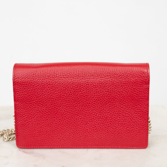 Red handbag on a white marble surface