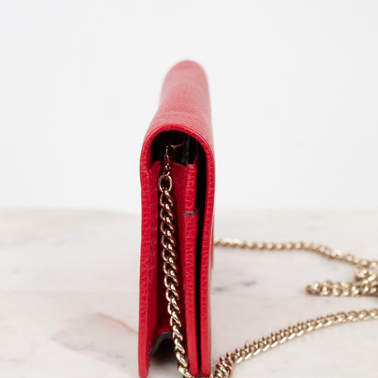 Red wallet with a gold chain on a white background