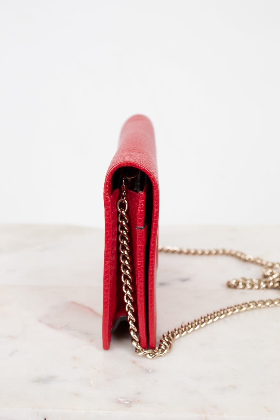 Red wallet with a gold chain on a white background