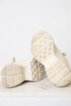 A pair of off-white Gucci chunky sneakers with white soles displayed on a light marble surface against a white background.