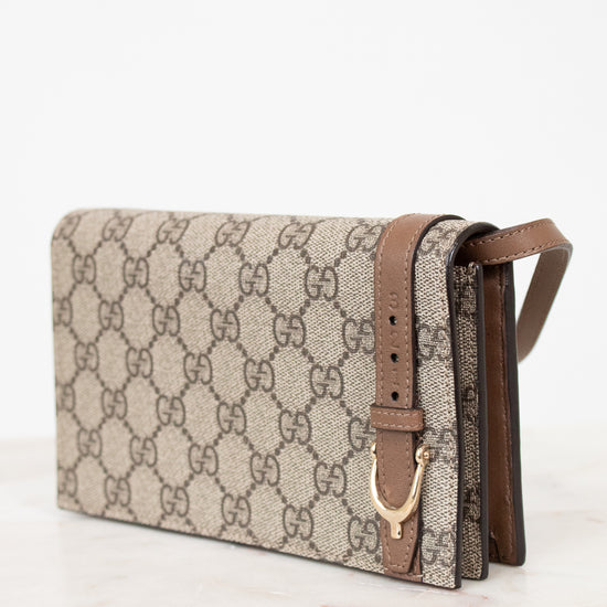 Beige handbag with brown strap on a white background