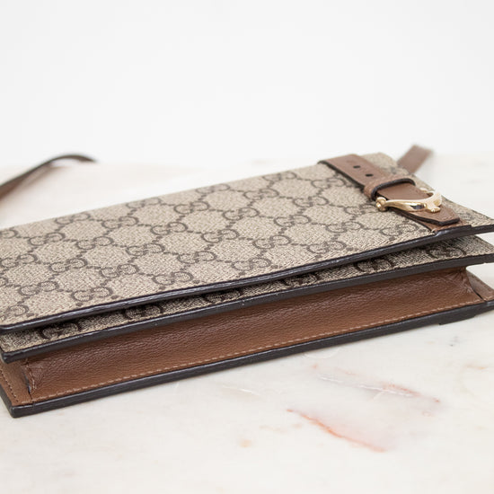 Designer handbag with patterned flap and brown base on a light background