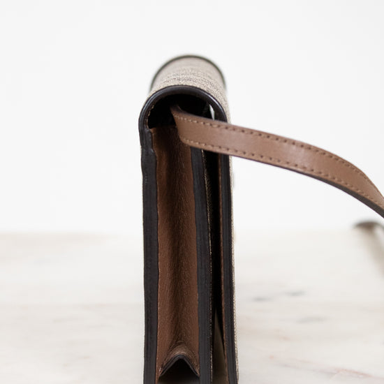 Close-up of a leather wallet with a strap on a white background