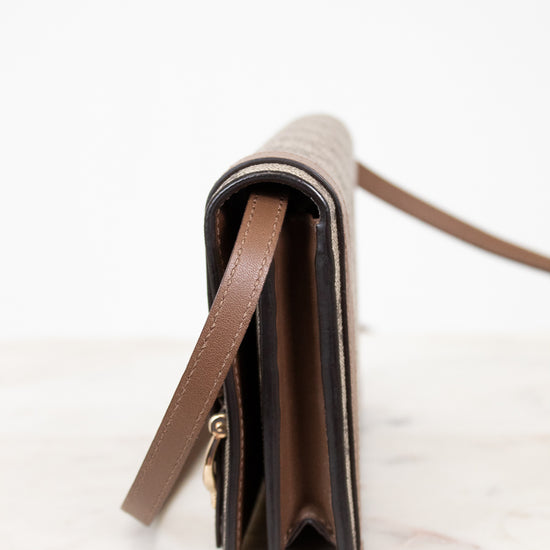 Close-up of a brown leather wallet with a strap on a white background