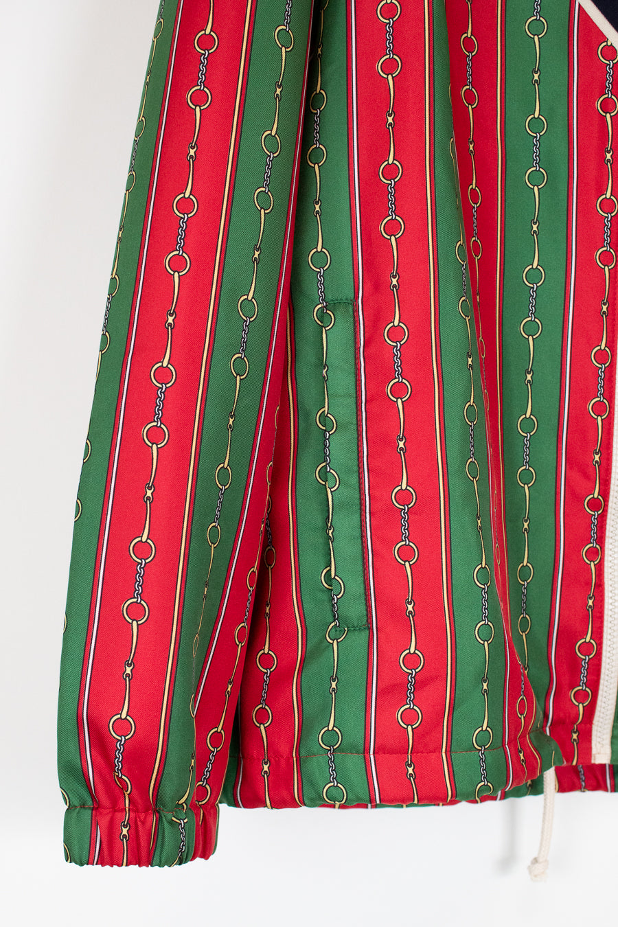 Red and green striped fabric with chain-like patterns on a white background