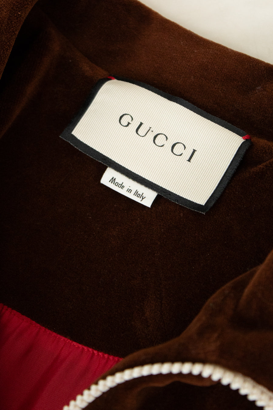 Gucci label on a brown garment with a white background