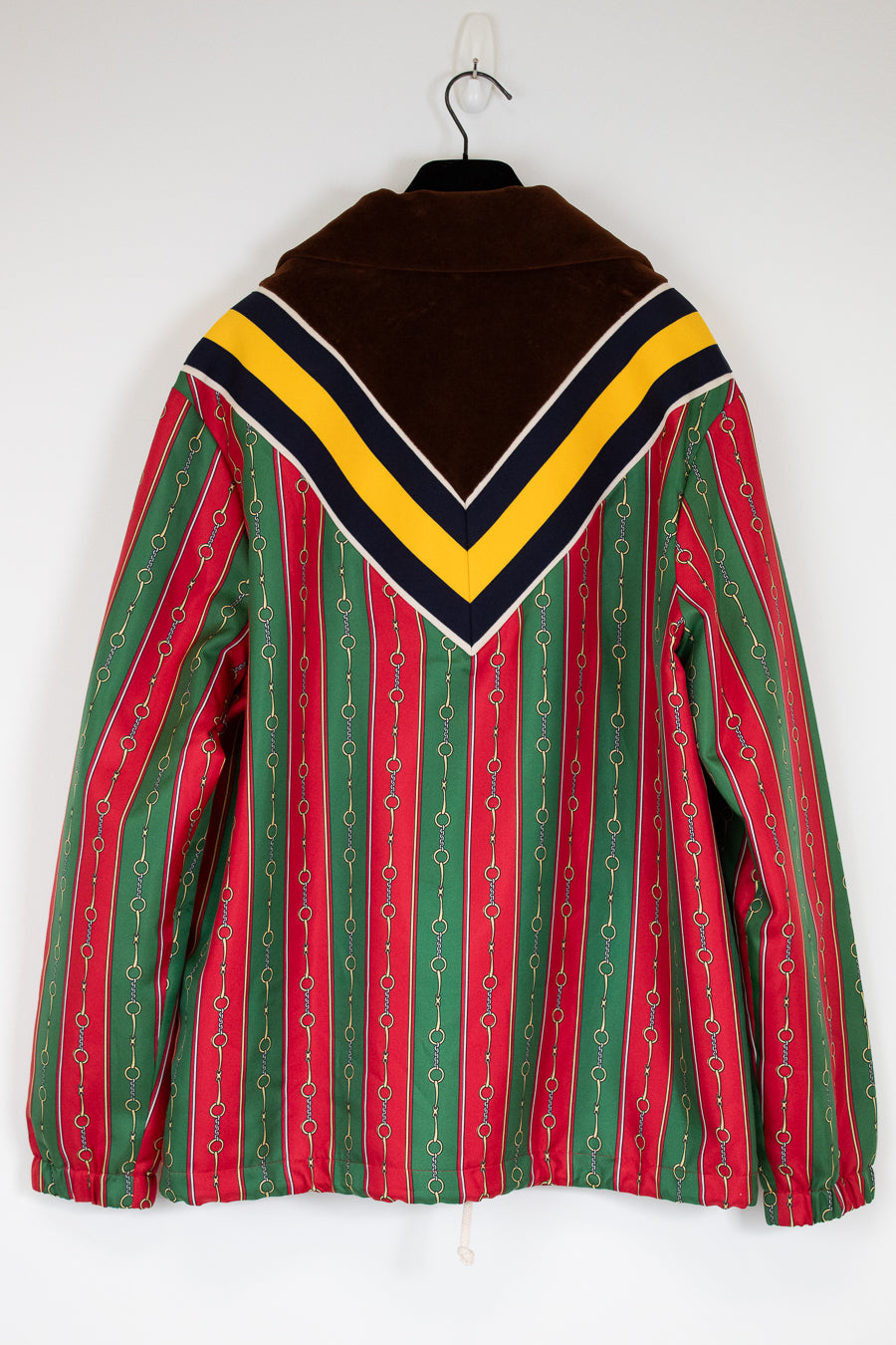 Colorful striped jacket with a high collar on a hanger against a white background