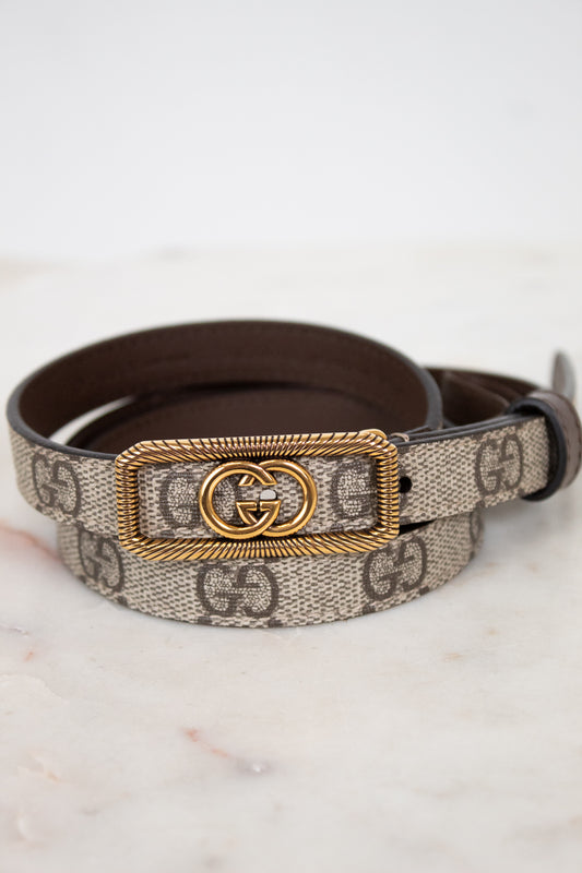Designer belt with gold buckle on a marble surface