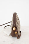 A Gucci shoulder bag in beige GG Supreme canvas with brown leather trim and gold-tone hardware, shown from a side profile on a light marble surface against a white background.