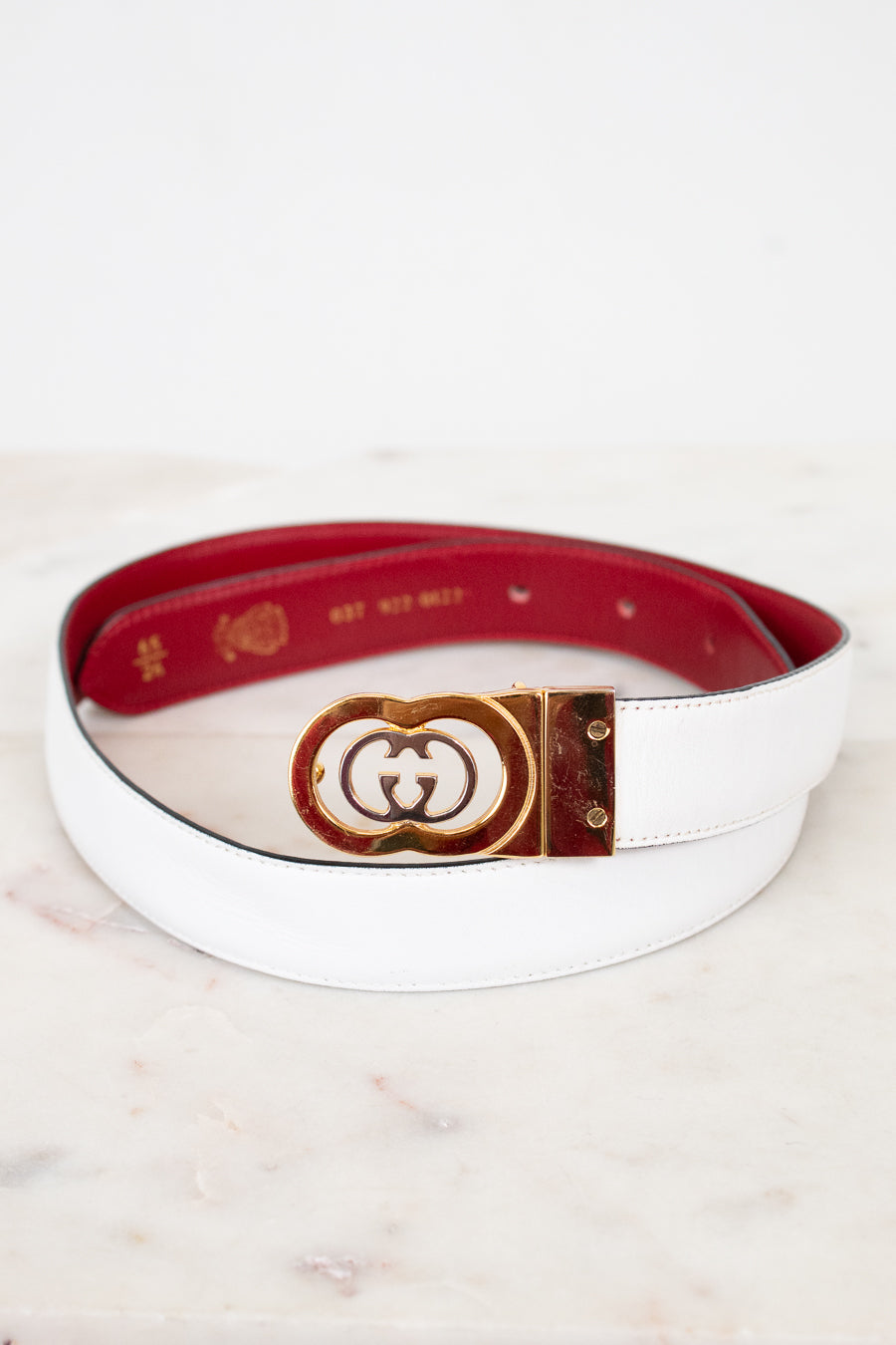 White and red reversible belt  on a marble surface