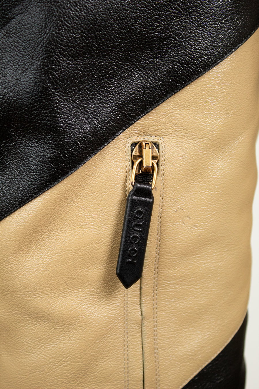 Close-up of 'GUCCI' black tab on zipper 