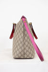 Beige handbag with pink strap on a white background