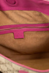 Close-up of a brown interior with pink zipper and visible Gucci logo.