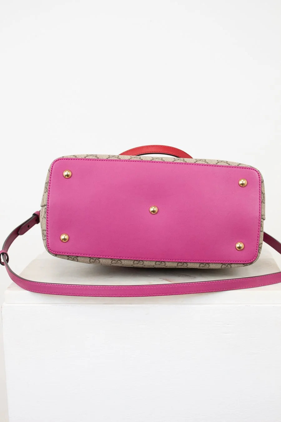 pink bottom of handbag with gold studs on a white background