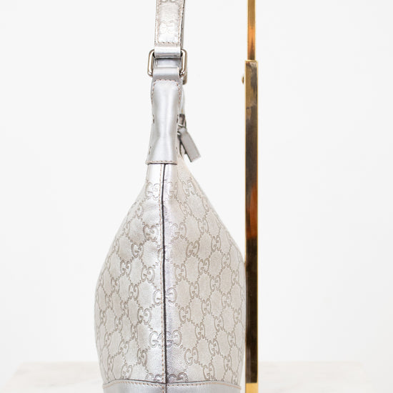 Silver handbag with gold accents on a white background