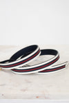 Navy blue, white and red striped belt on a marble surface