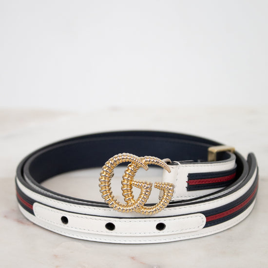Designer belt with gold buckle on a marble surface