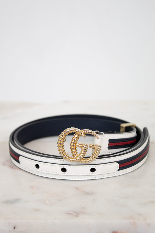 Designer belt with gold buckle on a marble surface