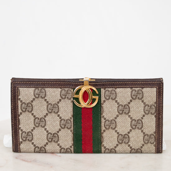 Designer wallet with brand logo and color stripe on a marble surface