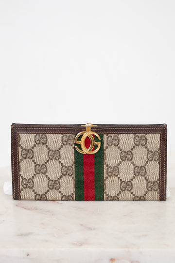 Designer wallet with brand logo and color stripe on a marble surface