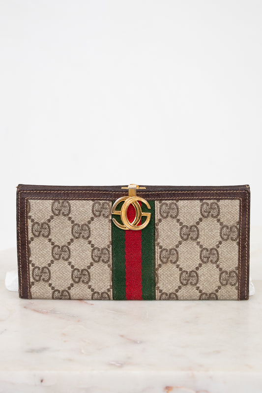 Designer wallet with brand logo and color stripe on a marble surface