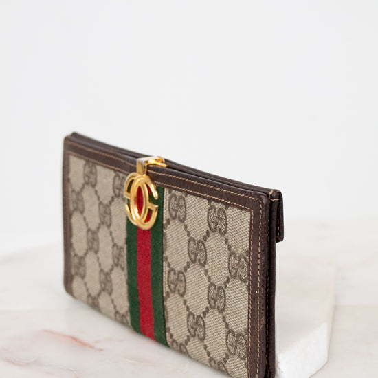 Gucci wallet with monogram pattern on a white background