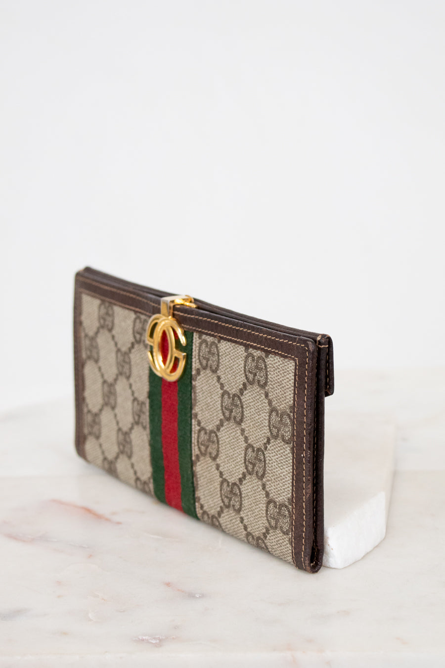 Gucci wallet with monogram pattern on a white background
