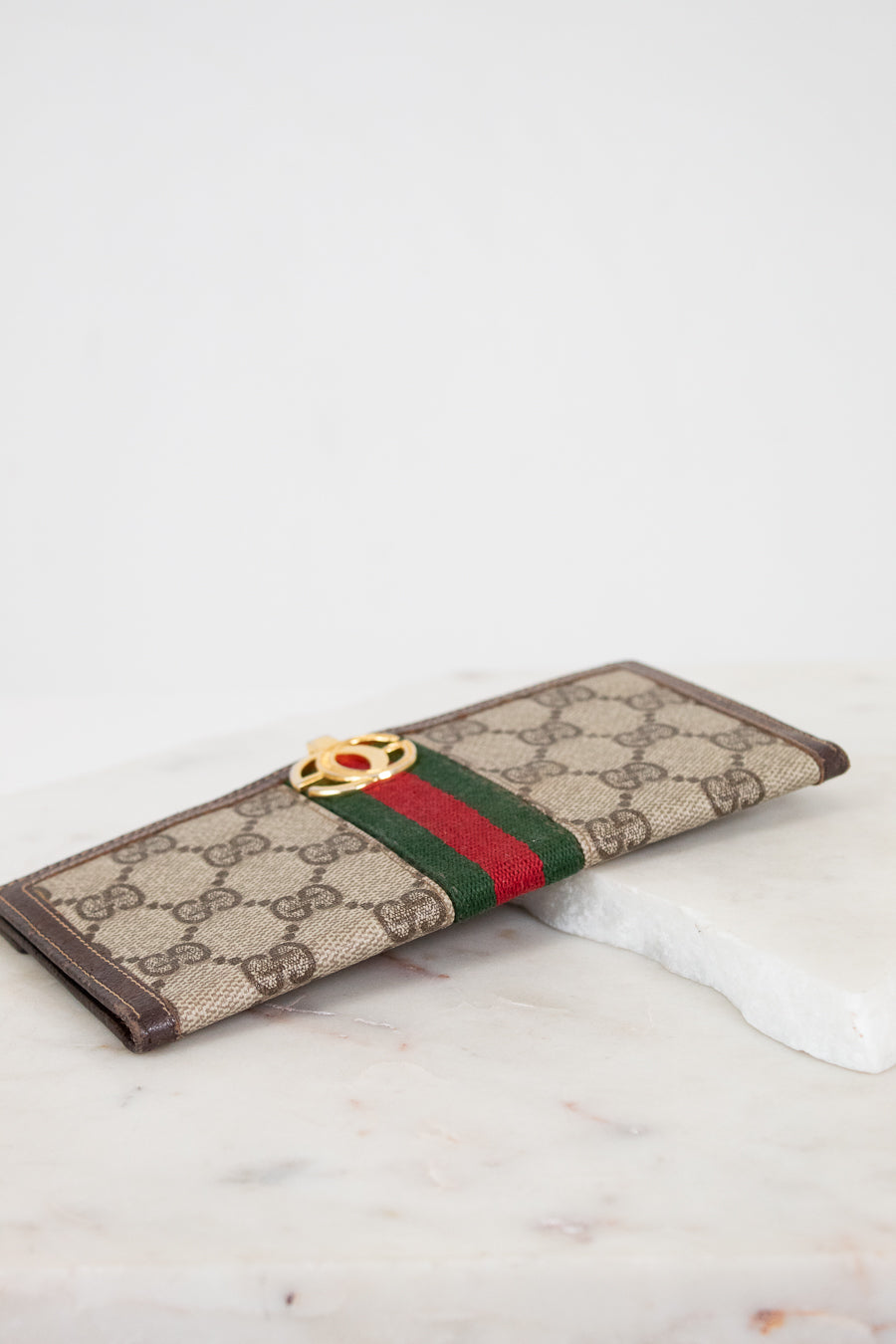 Designer wallet with brand logo on a marble surface
