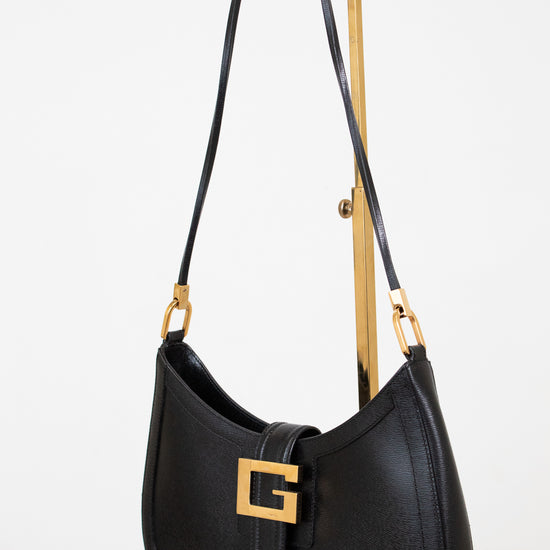Black handbag with gold accents on a white background 