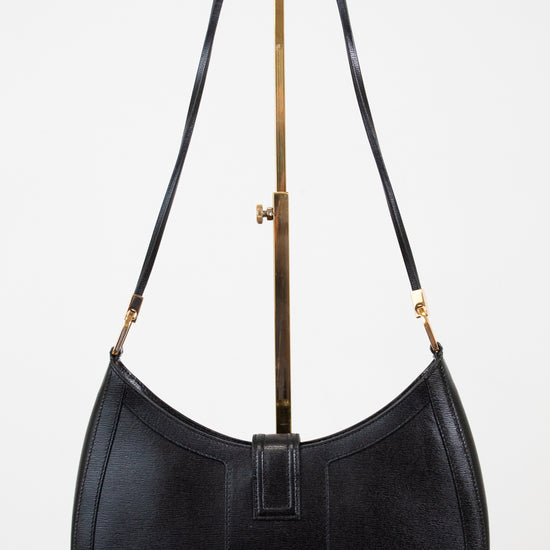 Black handbag with a gold clasp on a white background
