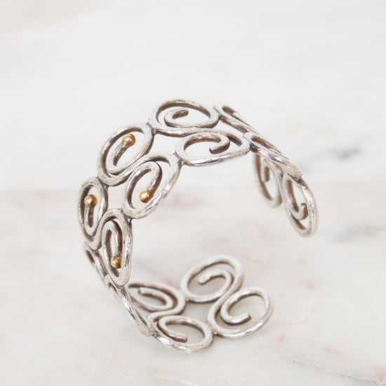 Silver bracelet with intricate designs on a marble surface