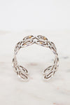 Side view of silver swirl cuff bracelet on white background