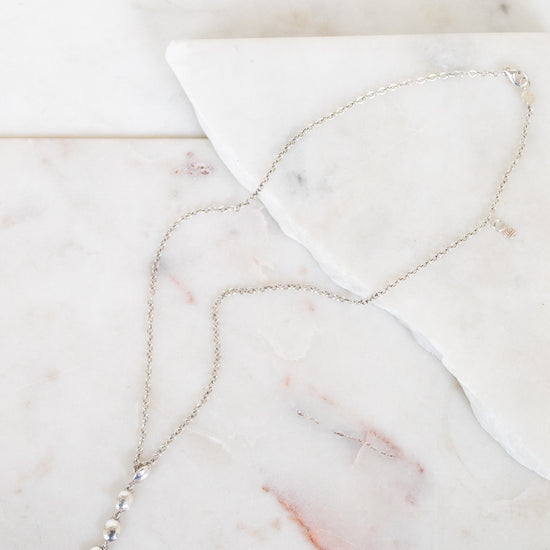 Silver necklace on marble surface 