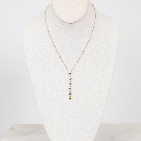 Necklace displayed on a mannequin bust against a white background