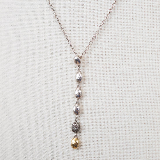 Necklace with hanging beads on a light gray background