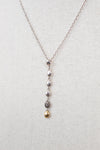 Necklace with hanging beads on a light gray background