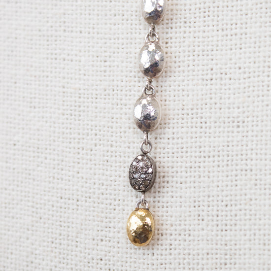 Silver and gold necklace on a textured white background
