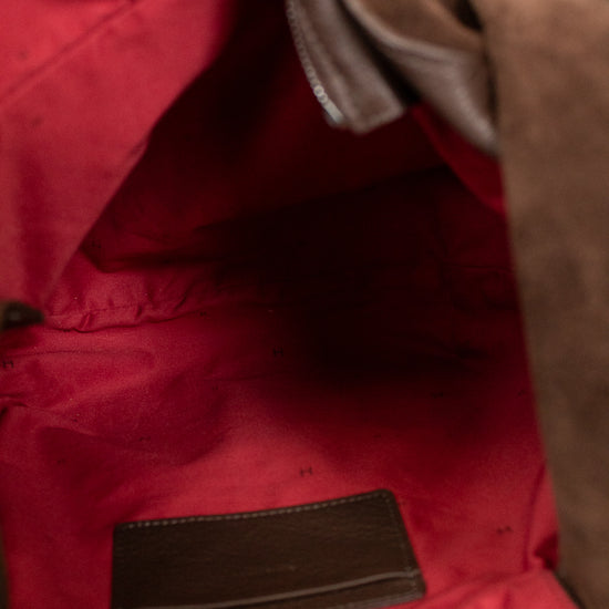 Close-up of a red bag with brown leather accents
