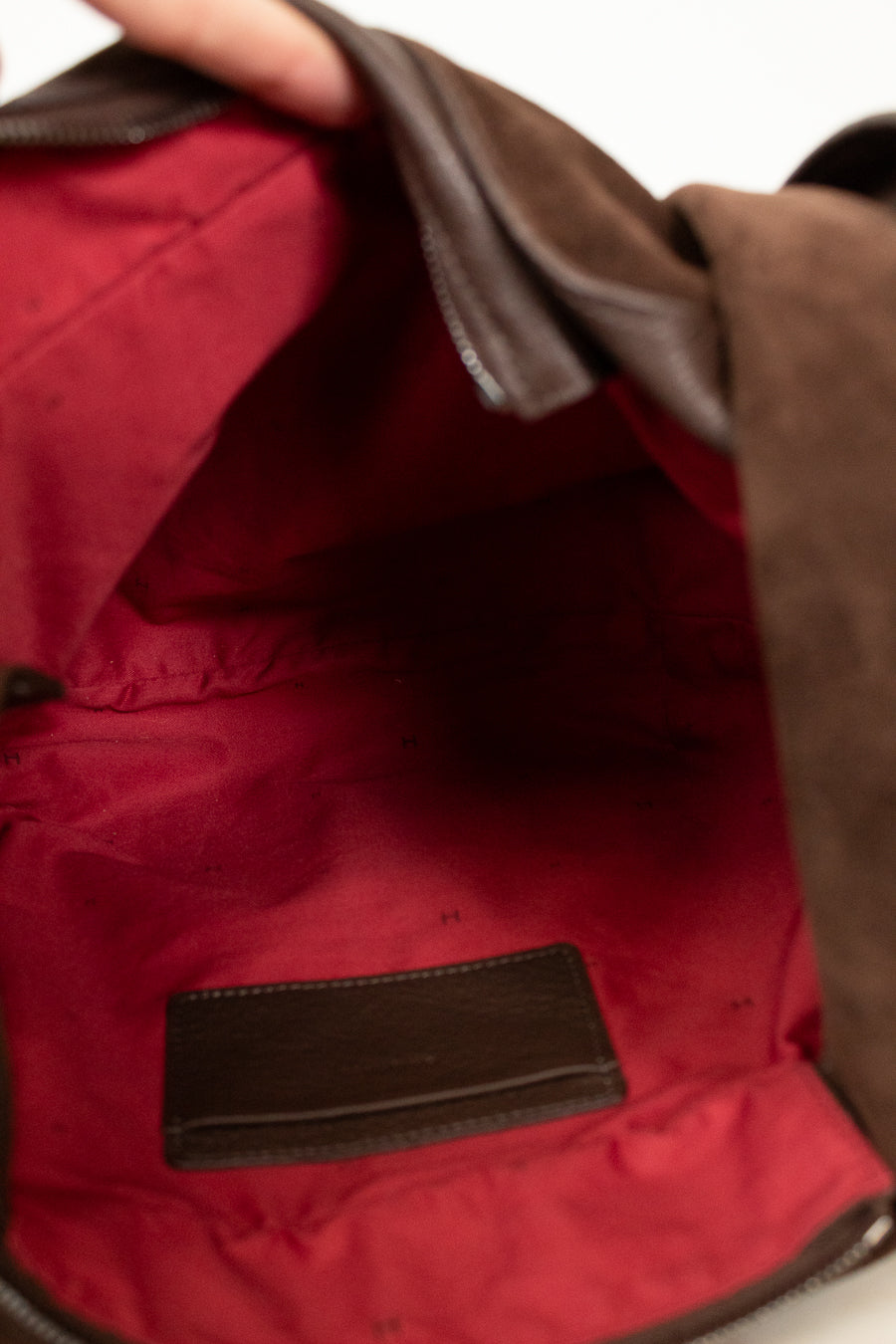 Close-up of a red bag with brown leather accents