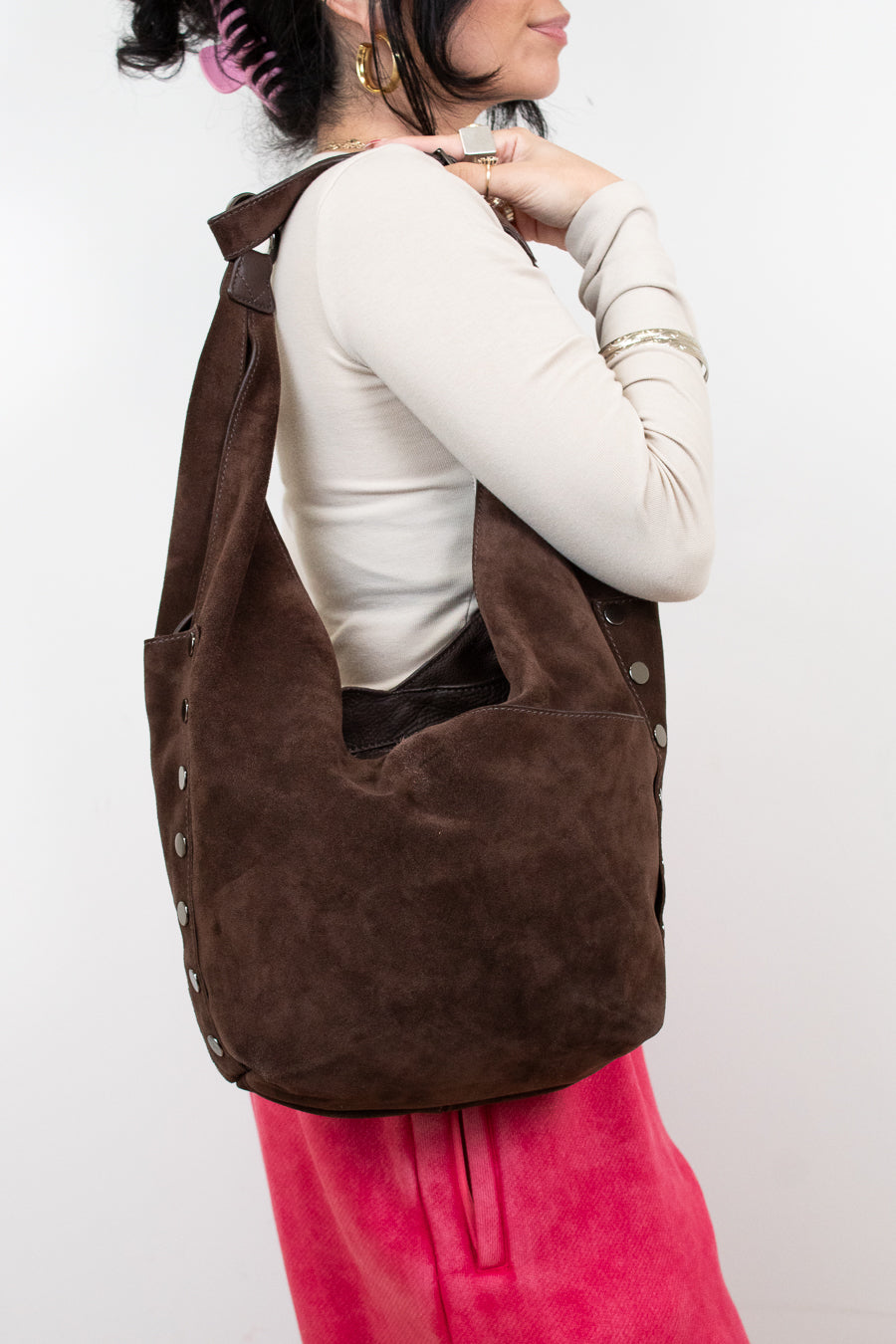 Person wearing a brown hobo bag on a white background