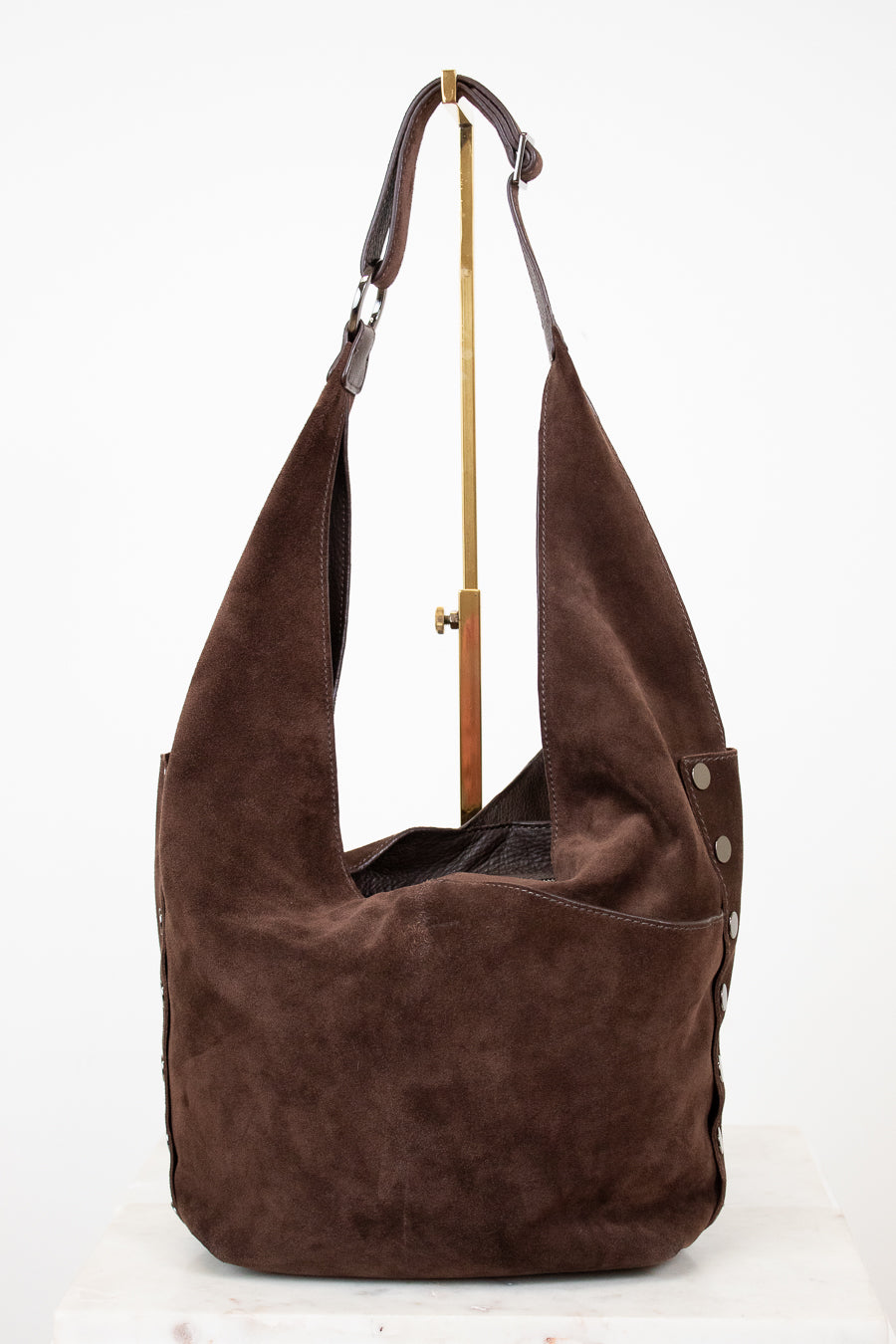 Brown suede handbag with a strap on a white background