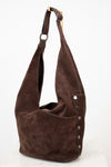 Brown suede handbag with a strap on a white background